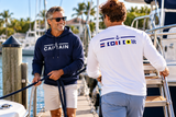 Boaters wearing a Captain performance shirt and nautical hoodie at the marina