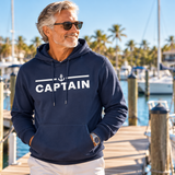 Man wearing navy Captain performance hoodie at a tropical marina